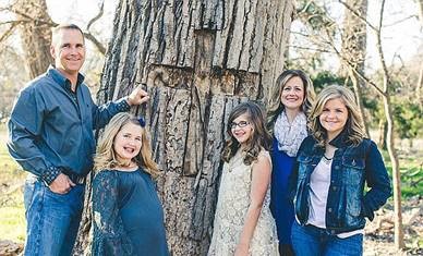 Annabel with her parents and sisters standing in front of the tree from which she fell.