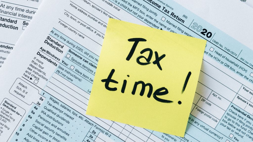 Picture of forms with a stick note that says "Tax Time".